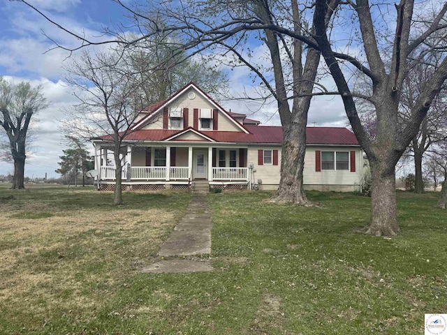 view of front of property featuring a front yard, metal roof, and a porch