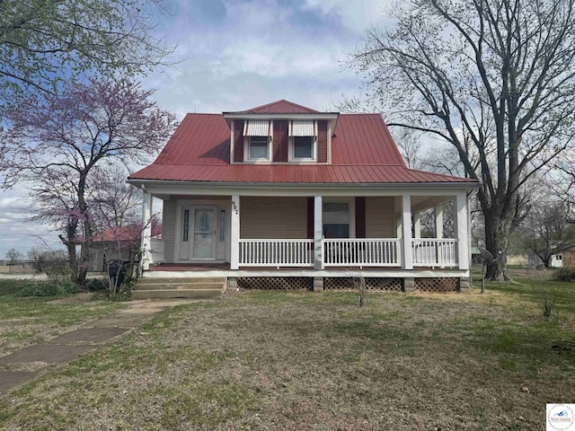 view of front facade featuring covered porch, metal roof, and a front yard