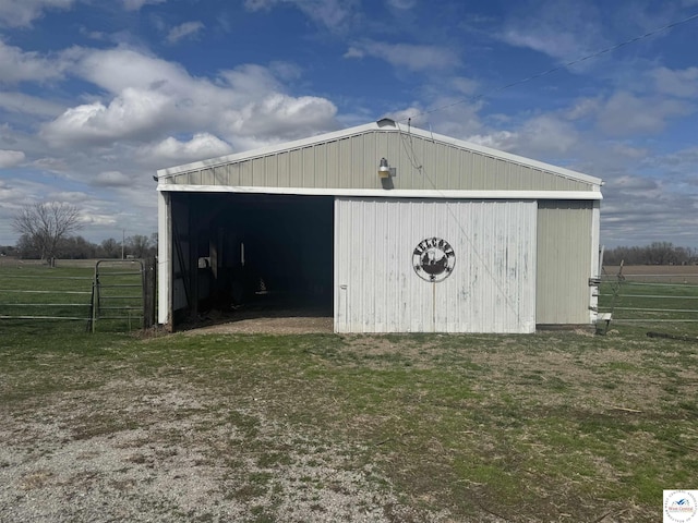 view of pole building with fence and a yard
