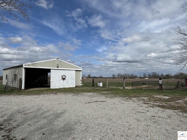 view of pole building with fence and a rural view