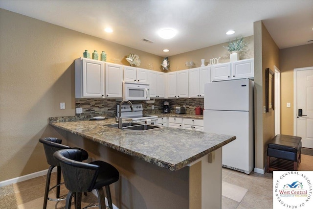 748 Pershing Dr, Camdenton, MO 65020 - kitchen featuring a kitchen breakfast bar, a peninsula, tasteful backsplash, and white appliances