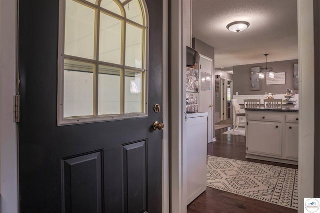 416 W Osage St, Warsaw, MO 65355 - foyer entrance with a chandelier, dark wood finished floors, and a textured ceiling