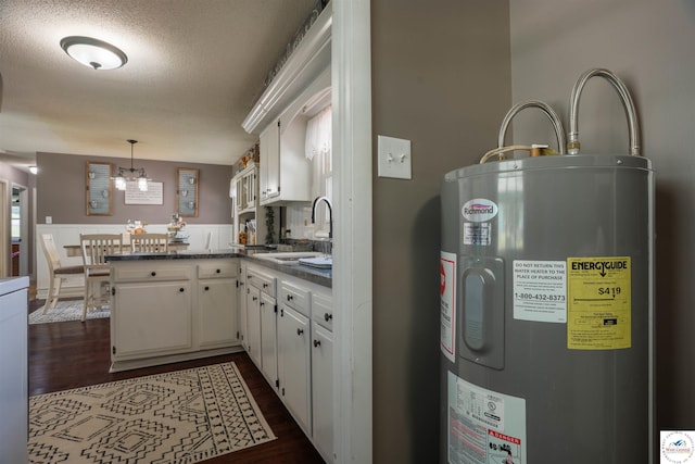 416 W Osage St, Warsaw, MO 65355 - kitchen with water heater, a peninsula, white cabinetry, dark wood-type flooring, and a textured ceiling
