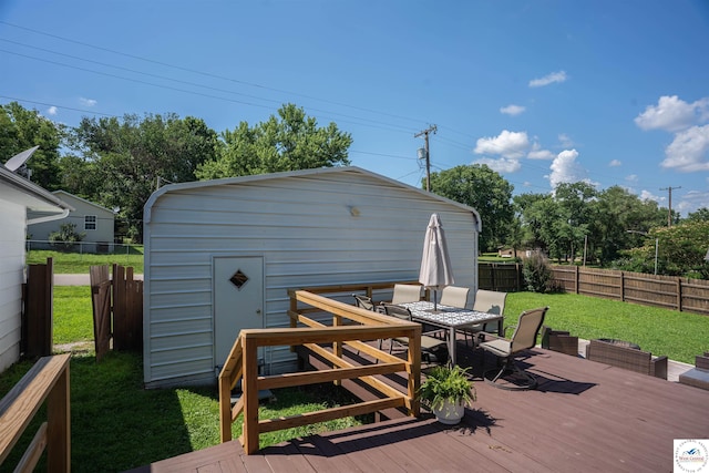 416 W Osage St, Warsaw, MO 65355 - wooden deck featuring outdoor dining space, a fenced backyard, an outbuilding, and a garage