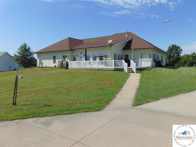 ranch-style house featuring a wooden deck and a front lawn
