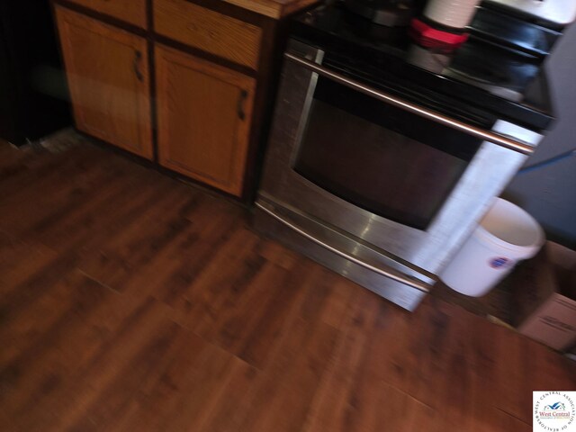 31591 Spring Ave, Warsaw, MO 65355 - kitchen with dark wood-style floors, stove, and brown cabinetry