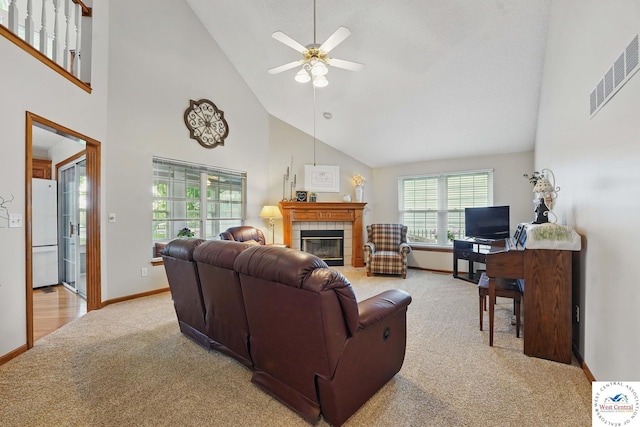 1515 NW Primrose Ln, Blue Springs, MO 64015 - living room with light carpet, a tiled fireplace, high vaulted ceiling, a ceiling fan, and baseboards