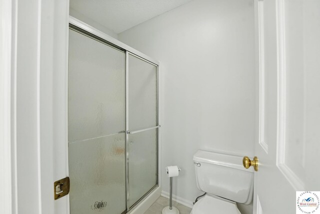 1515 NW Primrose Ln, Blue Springs, MO 64015 - full bathroom with toilet, a stall shower, tile patterned flooring, and baseboards