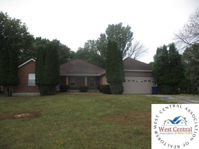 ranch-style house featuring driveway, an attached garage, and a front lawn