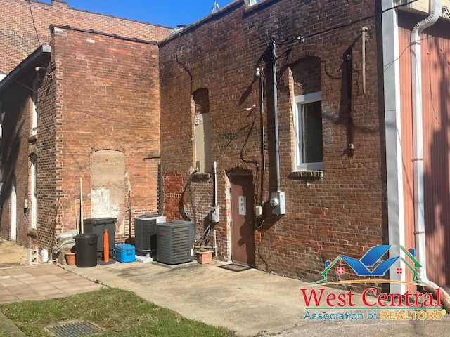 104 E Main St, Cole Camp, MO 65325 - view of side of home with central air condition unit and brick siding