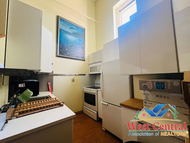 104 E Main St, Cole Camp, MO 65325 - kitchen with white appliances, light countertops, white cabinets, and dark wood finished floors