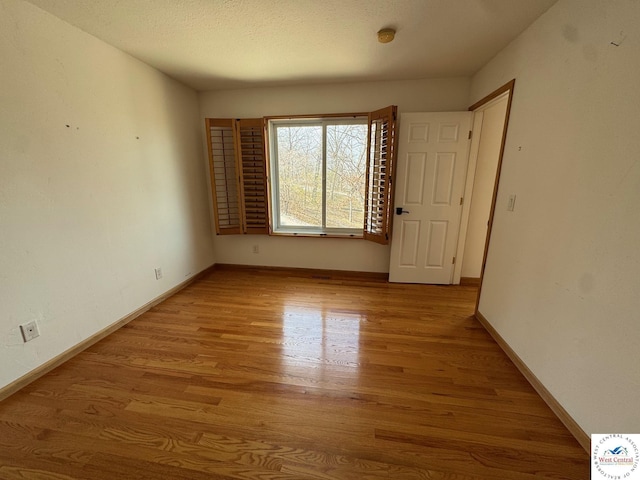 empty room with baseboards and wood finished floors