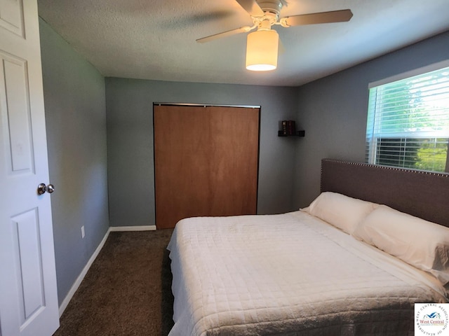 bedroom featuring dark colored carpet, a closet, baseboards, and a ceiling fan