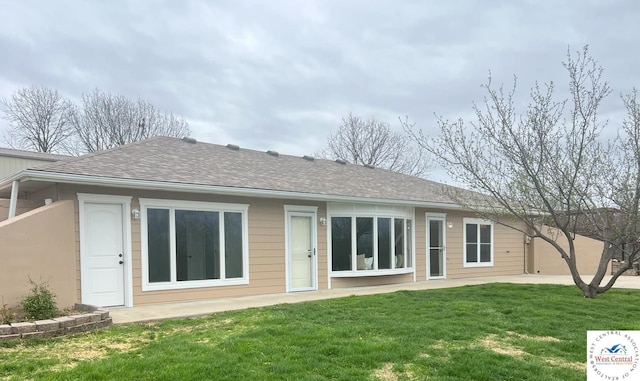rear view of house with a lawn, a patio, and a shingled roof