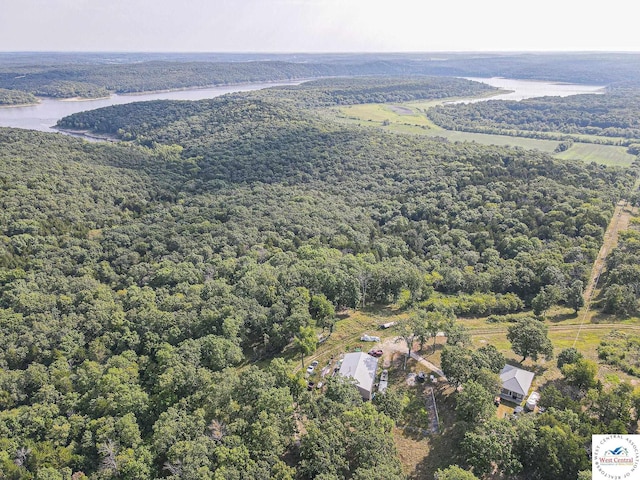 birds eye view of property with a water view and a view of trees