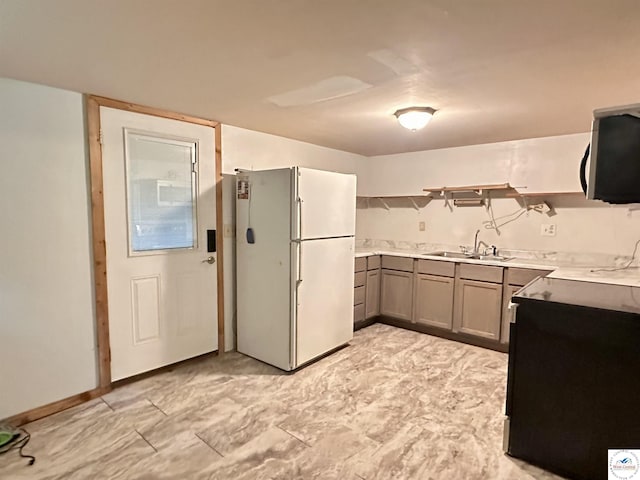 23651 Pifer St, Warsaw, MO 65355 - kitchen with freestanding refrigerator, a sink, open shelves, stainless steel microwave, and gray cabinetry