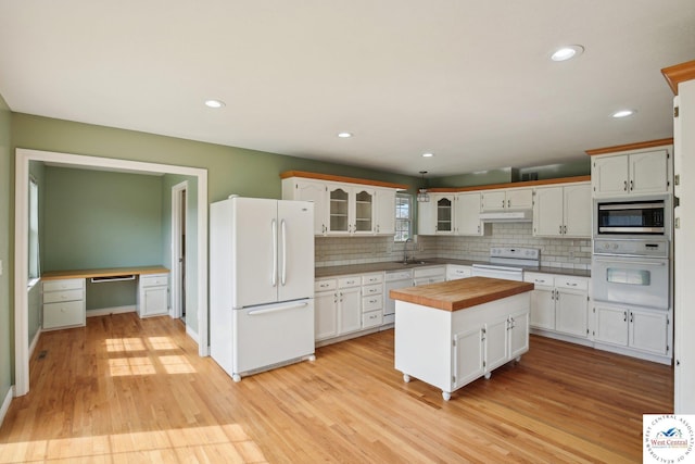 29950 Binder Rd, Green Ridge, MO 65332 - kitchen featuring white appliances, a sink, under cabinet range hood, white cabinets, and tasteful backsplash