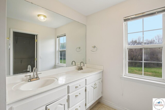 29950 Binder Rd, Green Ridge, MO 65332 - full bathroom with double vanity, baseboards, tile patterned floors, and a spacious closet