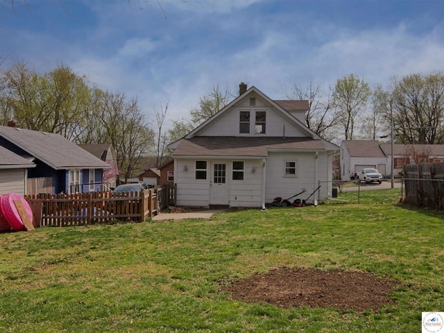 back of property featuring a chimney, fence, and a yard