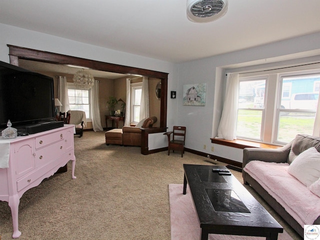 living room featuring baseboards, visible vents, a notable chandelier, and light colored carpet