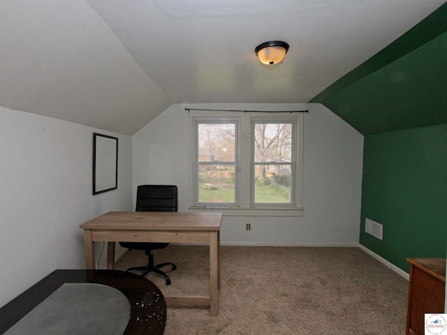 carpeted office featuring lofted ceiling and baseboards
