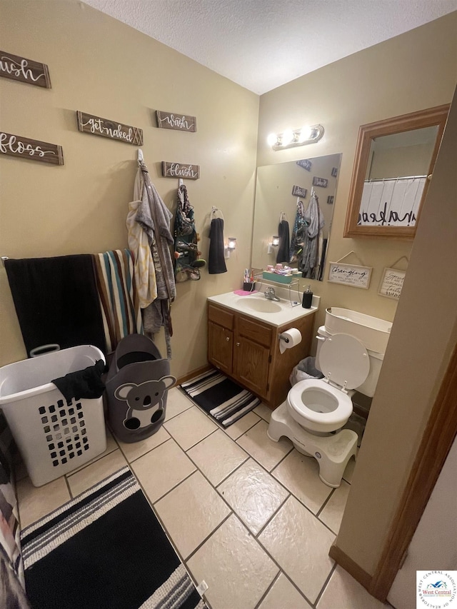 725 N Max Stevens St, Adrian, MO 64720 - full bathroom with toilet, vanity, tile patterned floors, and a textured ceiling