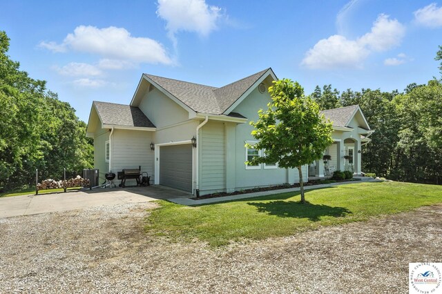 917 N Washboard Rd, Sibley, MO 64088 - view of home's exterior with concrete driveway, an attached garage, a lawn, and a shingled roof