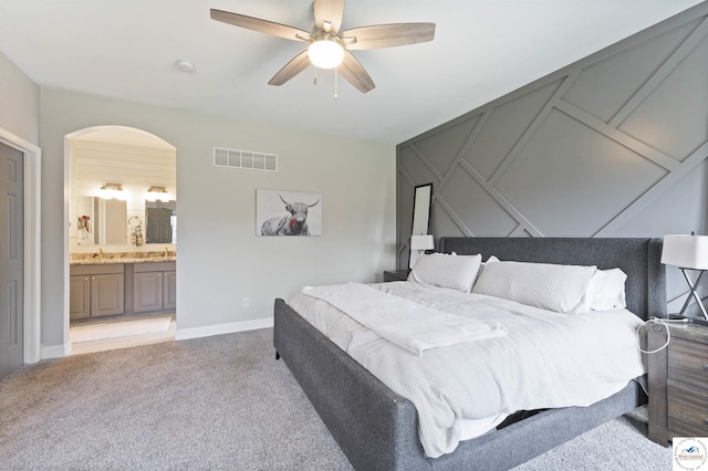 917 N Washboard Rd, Sibley, MO 64088 - bedroom featuring light colored carpet, arched walkways, a sink, ensuite bathroom, and a ceiling fan