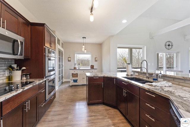 917 N Washboard Rd, Sibley, MO 64088 - kitchen with a sink, stainless steel appliances, wood finished floors, light stone counters, and hanging light fixtures