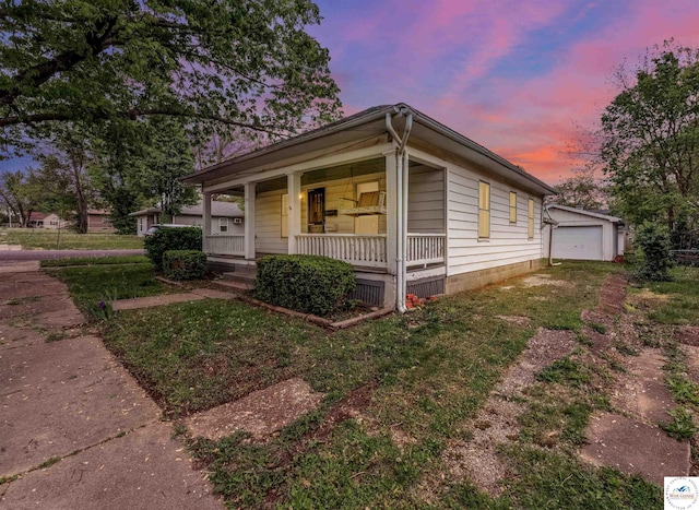 view of front of property with covered porch, an outdoor structure, and a detached garage