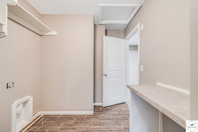 clothes washing area featuring wood tiled floors and baseboards