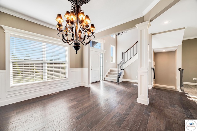 unfurnished dining area with a chandelier, dark wood finished floors, crown molding, stairway, and wainscoting
