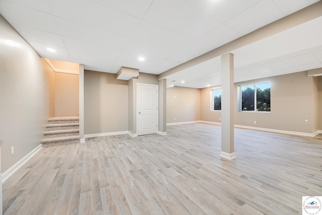 basement with light wood-type flooring, baseboards, stairway, a drop ceiling, and recessed lighting