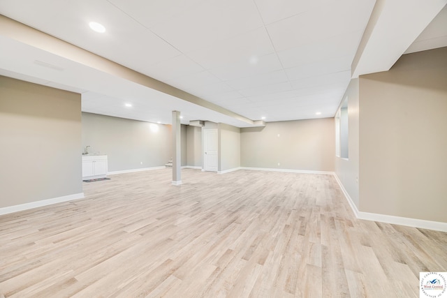 finished below grade area with light wood-style floors, baseboards, and recessed lighting