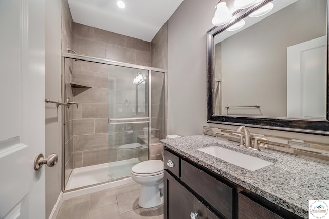 bathroom with a shower stall, toilet, tile patterned flooring, and vanity