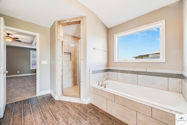 bathroom featuring a stall shower, a bath, lofted ceiling, a ceiling fan, and baseboards