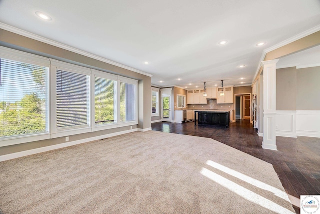 unfurnished living room with crown molding, recessed lighting, dark wood-type flooring, decorative columns, and baseboards