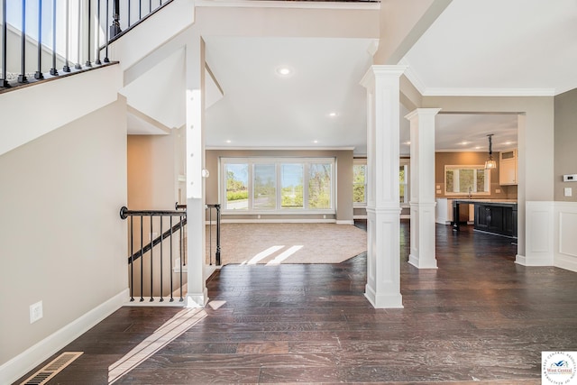 entrance foyer with decorative columns, crown molding, wood finished floors, baseboards, and recessed lighting
