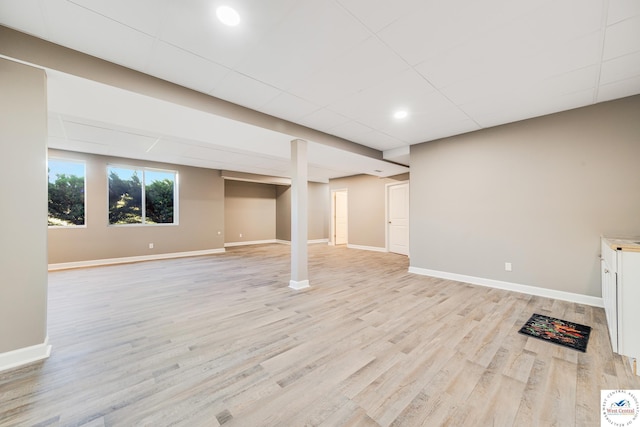 below grade area featuring light wood-style floors and baseboards