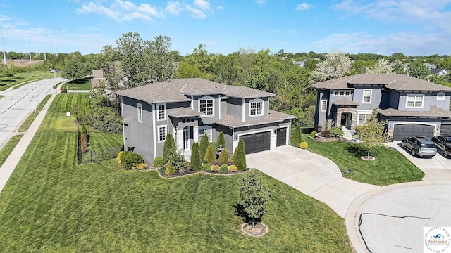 view of front of property featuring concrete driveway, a front yard, and a garage