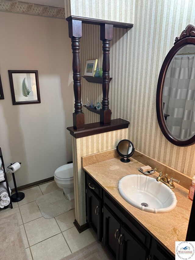 101 N Connie Dr, Clinton, MO 64735 - bathroom featuring tile patterned floors, wallpapered walls, toilet, vanity, and baseboards