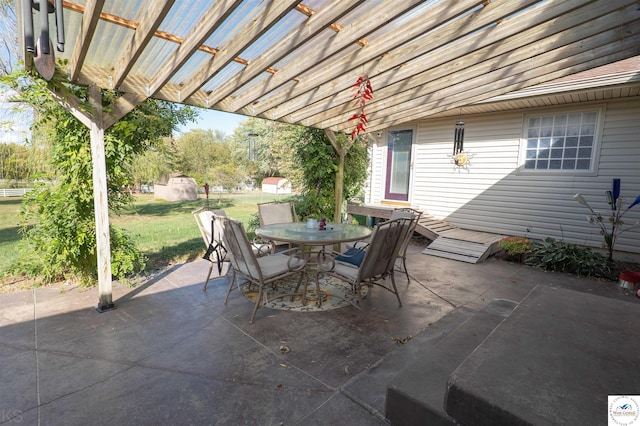 view of patio featuring a storage unit, a pergola, an outdoor structure, and outdoor dining area