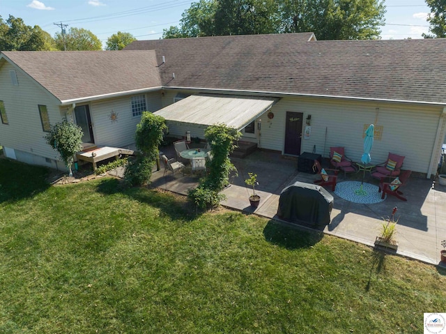back of house with roof with shingles, a patio area, a yard, and a wooden deck