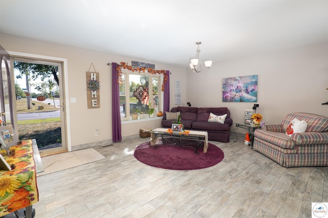 living area featuring an inviting chandelier, wood finished floors, and visible vents