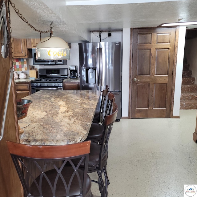 31150 Highview Rd, Edwards, MO 65326 - kitchen featuring appliances with stainless steel finishes, a breakfast bar area, and brown cabinetry