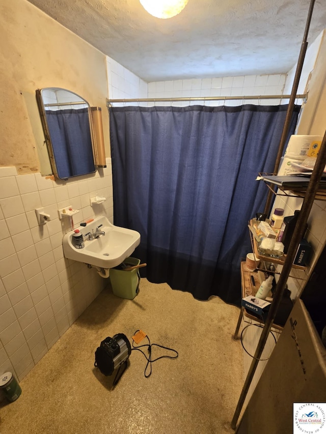 808 E 19th St, Sedalia, MO 65301 - bathroom featuring tile walls, a sink, curtained shower, a textured ceiling, and wainscoting