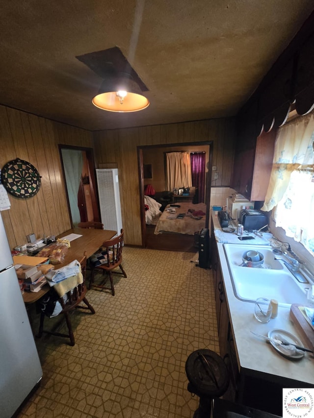 808 E 19th St, Sedalia, MO 65301 - interior space featuring wood walls, freestanding refrigerator, and a sink
