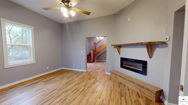 607 E Benton St, Windsor, MO 65360 - unfurnished living room featuring baseboards, ceiling fan, stairway, and light wood-type flooring