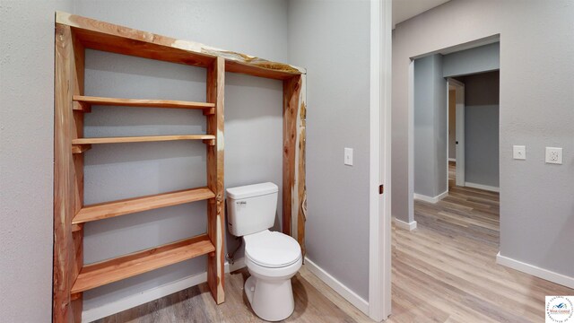 607 E Benton St, Windsor, MO 65360 - bathroom featuring baseboards, wood finished floors, and toilet