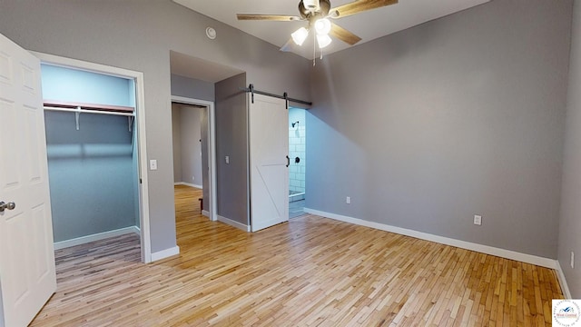 607 E Benton St, Windsor, MO 65360 - unfurnished bedroom with light wood-style floors, a barn door, a closet, baseboards, and a ceiling fan